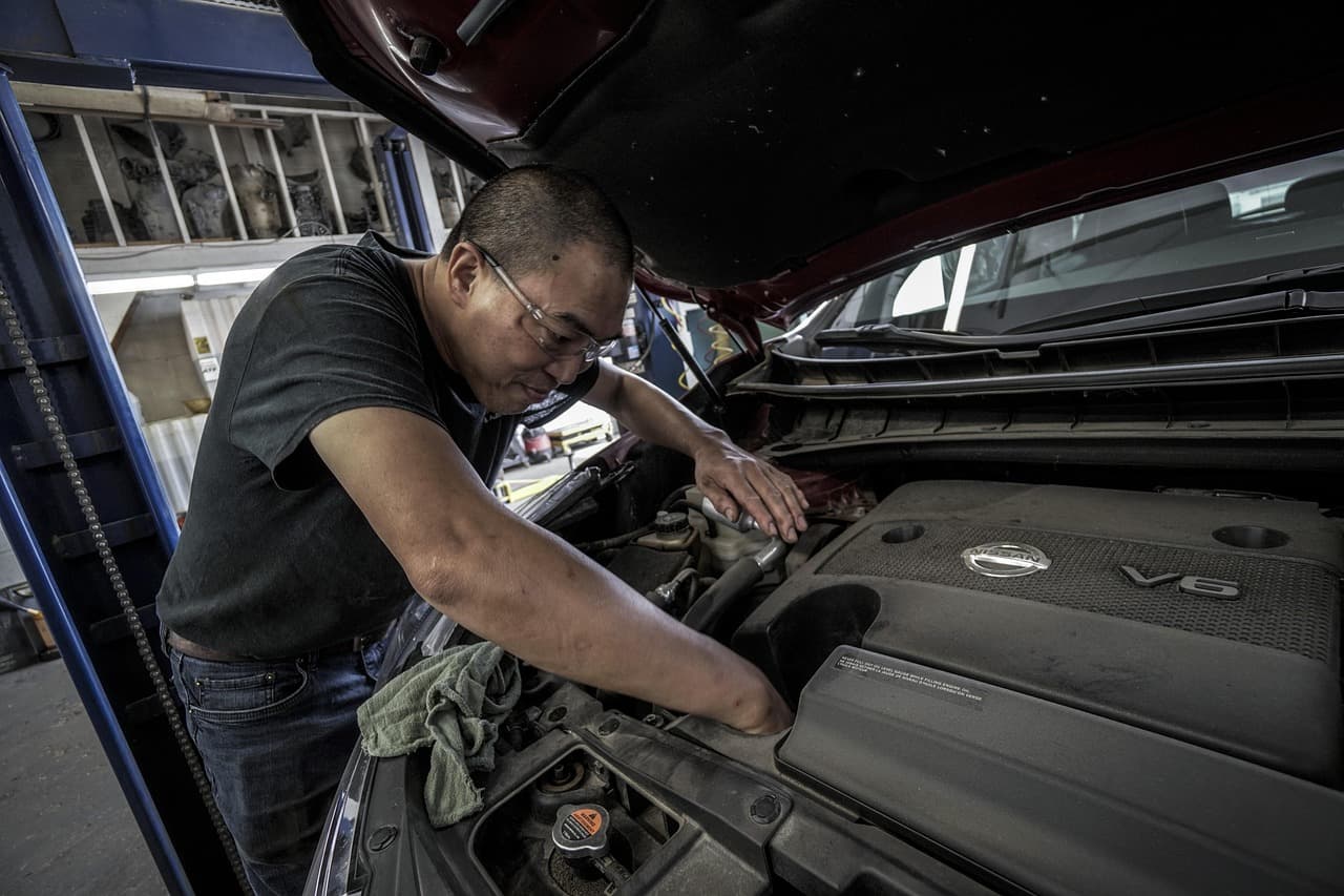 A mechanic leaning into the engine bay during a service